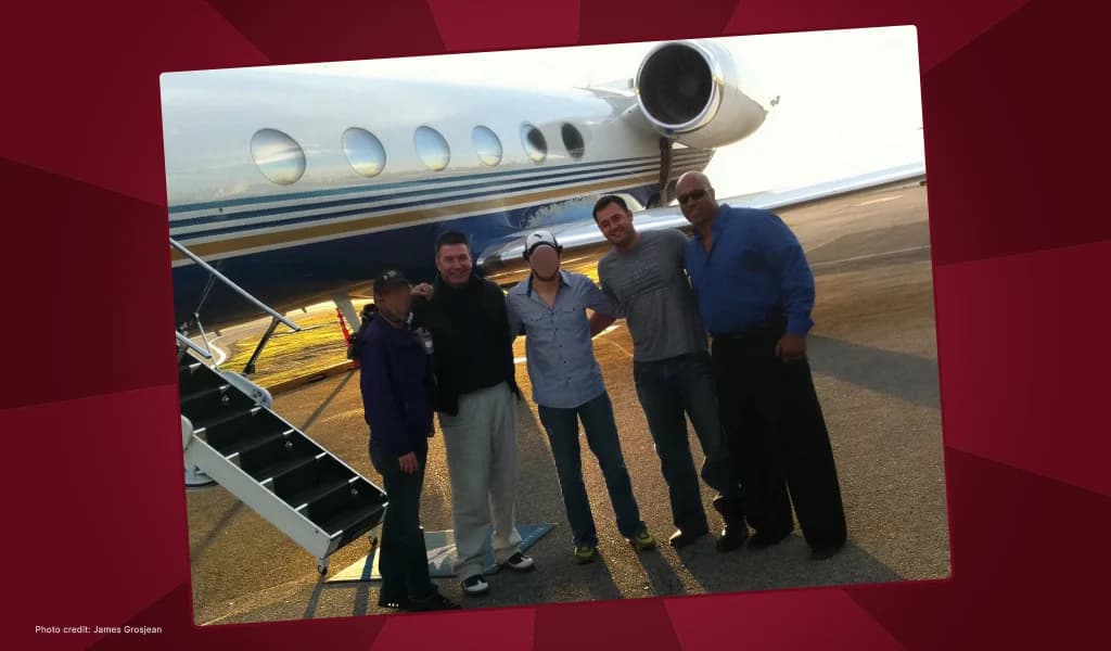 Don Johnson and his team posing in front of a private jet on the tarmac.