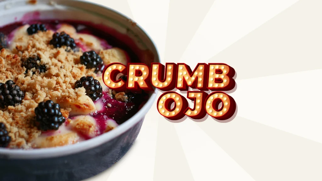 With an off-white background, there’s a bowl of blackberry and pear crumble and the words ‘Crumb ojo’ on the right in marquee lights.