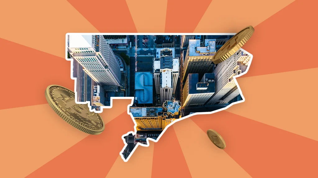 The city of Detroit is shown within the city’s border, and three Bitcoins hover above and on the sides. It’s all shown on a two-toned peach background. 