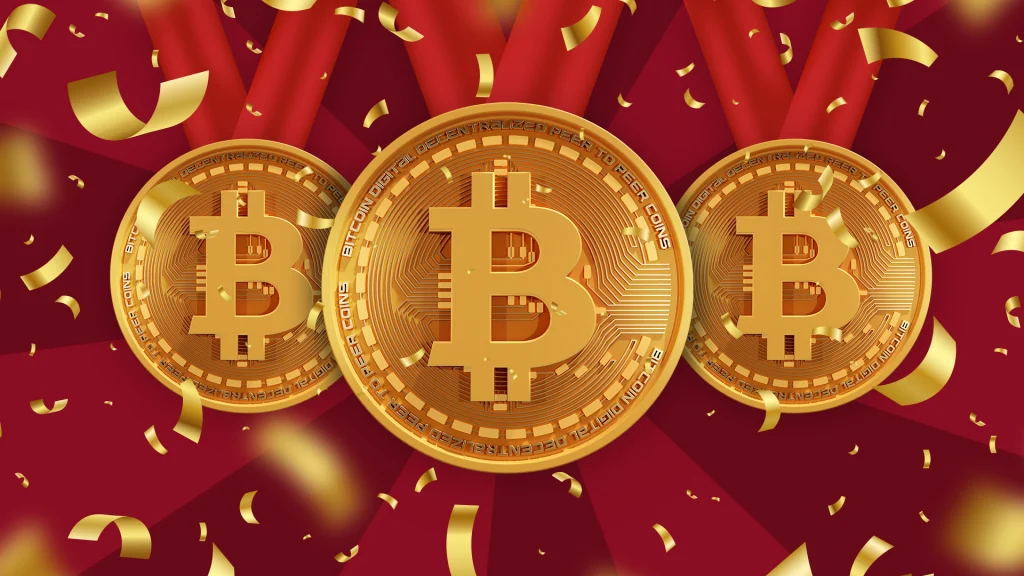 Three gold Bitcoins are lined up on a dark red background with gold confetti exploding. 