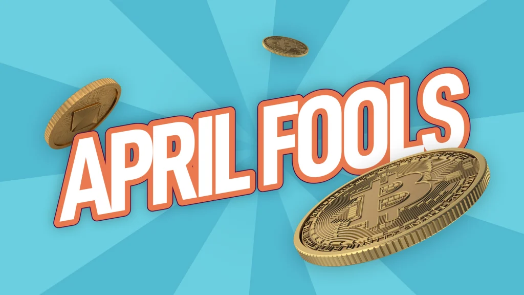 Golden cryptocurrency coins floating in the air with bold, playful text reading 'APRIL FOOLS' against a bright blue background, suggesting a crypto-related prank.