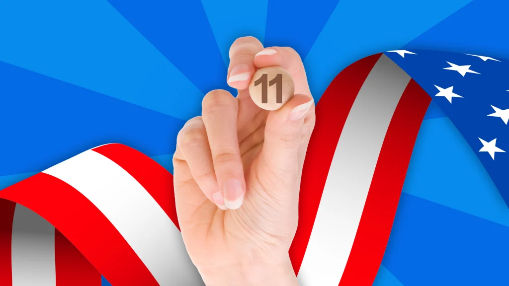a hand holds a bingo 11 ball with US flag ribbon and blue background