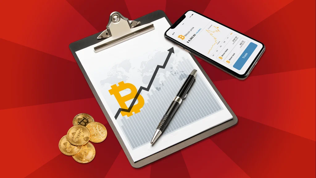 A notebook in the center of a bright red image shows the symbol for Bitcoin and an arrow indicating that the price is going up. A pen is on the clipboard, gold coins are piled to its left, and a mobile phone is displayed on its right. 